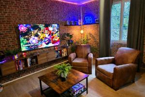 a living room with a tv and a brick wall at L atelier des jeux in Beauvais