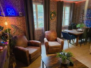 a living room with leather chairs and a table at L atelier des jeux in Beauvais