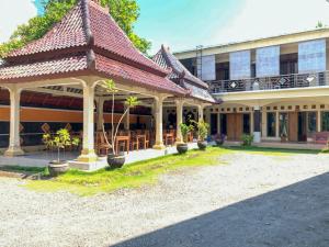 a building with a gazebo with tables and chairs at Hotel Syariah Milik Kita Borobudur Mitra RedDoorz in Borobudur