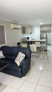 a living room with a blue couch and a table at 4 bedrooms with queen sized bed each room in Riverview