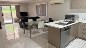 a kitchen with a table and chairs and a dining room at 4 bedrooms with queen sized bed each room in Riverview +6 photos