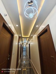 a hallway in a building with a ceiling with a chandelier at Hotel Akshansh Inn in Agra