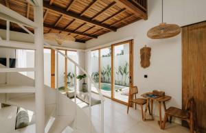 a room with a staircase and a living room at Palm Valley Loft in Kuta Lombok