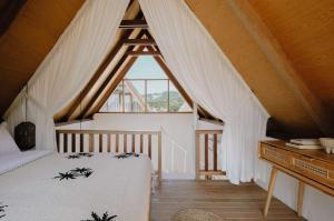 a bedroom with a white bed and a window at Palm Valley Loft in Kuta Lombok