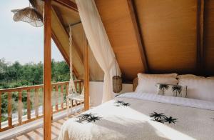 a bedroom with a bed and a balcony at Palm Valley Loft in Kuta Lombok +18 photos