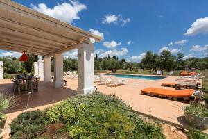 Un patio con piscina y sillas en Villa Rosalore' by Perle di Puglia, en Ugento