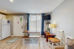 a kitchen with a table and a desk and a refrigerator at Sea Treasures Inn #114 in Rockaway Beach