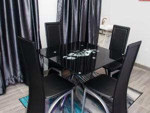 a black dining room table with four black chairs at Shepherd Spring Apartments in Gbogije