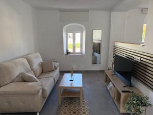 a living room with a couch and a tv at CasaElbarranko in Arcos de la Frontera