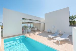 a house with a swimming pool and two chairs at Villa Rubi in Platja d'Aro
