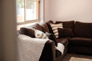 a brown couch in a living room with a window at The Laneway - 3BR, Pet Friendly, Walk to CBD in Port Lincoln +26 photos
