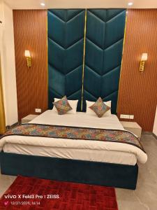 a bedroom with a large bed with a blue headboard at Hotel Akshansh Inn in Agra +25 photos