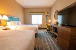 a hotel room with two beds and a flat screen tv at Hampton Inn & Suites College Station in College Station +48 photos