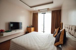 a hotel room with a bed and a flat screen tv at EcoHouse Boutique Hotel Huế in Hue