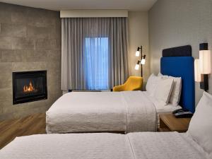 a hotel room with two beds and a fireplace at Hampton Inn Pigeon Forge in Pigeon Forge +9 photos