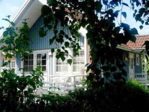 a blue and white house with a white porch at Moorfrosch in Userin
