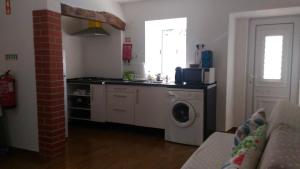 a kitchen with a sink and a washing machine at Visitar Bioucas II - Casa Tradicional Familiar in Bioucas