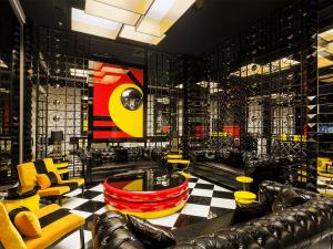 um bar com cadeiras amarelas e vermelhas e um piso xadrez em Ramada Hotel & Suites by Wyndham Istanbul- Sisli em Istambul