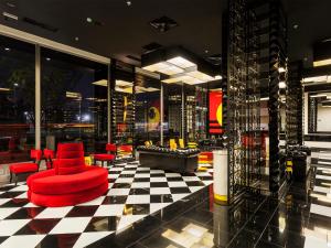 um átrio com uma cadeira vermelha e um piso xadrez em Ramada Hotel & Suites by Wyndham Istanbul- Sisli em Istambul
