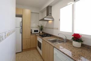 a kitchen with a sink and a stove top oven at Apartamento Frente al Mar in Bellreguart