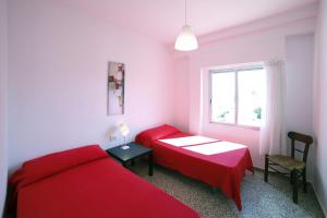 ベルレガートにあるApartamento frente al marのベッドルーム1室(赤いベッド2台、窓付)