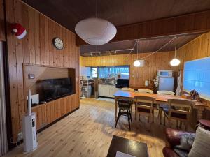 a kitchen and dining room with a table and a clock at 嬉々の屋KIKI Chalet in Hakuba