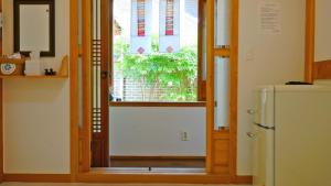a door to a kitchen with a window and a refrigerator at Hanok Onew in Jeonju