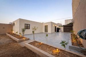 a house with a courtyard with palm trees and lights at نسيم العلا - Naseem AlUla in Al-ʿUla