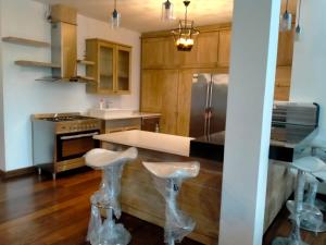 a kitchen with wooden cabinets and a counter with bar stools at Dilvilla in Nikawatawana