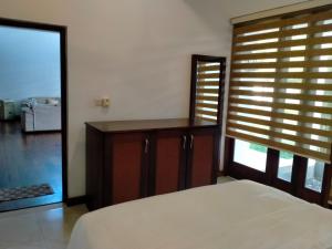 a bedroom with a bed and a window with a shutter at Dilvilla in Nikawatawana