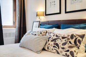 una camera da letto con un letto con cuscini sopra di Repubblica Central Suite a Roma