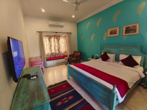 a bedroom with a bed and a television in it at Pushkar Fort - Luxury Heritage Resort in Pushkar