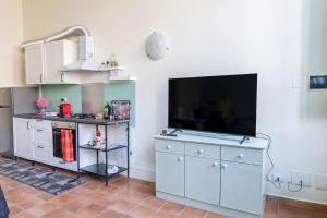 a kitchen with a flat screen tv on the wall at Principi di Piemonte Apartments in Tirrenia