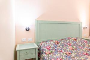 a bedroom with a bed with a large headboard at Principi di Piemonte Apartments in Tirrenia