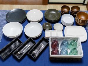 a blue table topped with white and black plates and bowls at わのおうち善 in Nitanzawa