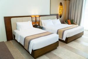 a hotel room with two beds and a couch at Coron Westown Resort Premier in Sampong +56 photos