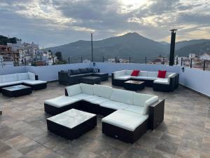 a patio with couches and tables on a roof at B&B Ágora in Sayalonga +8 photos