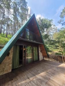a house with a large deck with a balcony at Monsoon Cabana Ella in Ella
