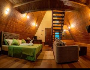 a living room with a bed and a spiral staircase at Monsoon Cabana Ella in Ella