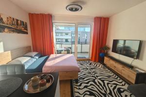 a bedroom with a bed and a tv and a window at Rezidencia Albelli in Košice