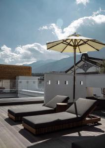 a patio with an umbrella and chairs and a table at CHUN LIN BOUTIQUE HOTEL in Dali