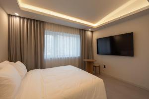 a hotel room with a bed and a flat screen tv at 신북 온심재 in Sajŏng-dong +62 photos
