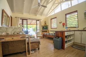 a living room with a bed and a kitchen at Whispering Palms - Absolute Beachfront Villas in Port Vila