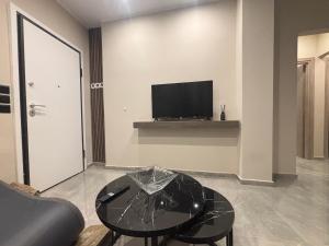 a living room with a glass table and a tv at Athens Air B&B in Athens