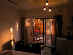 a living room with a table and chairs and a sliding glass door at Picasso - Zur See in Ballito