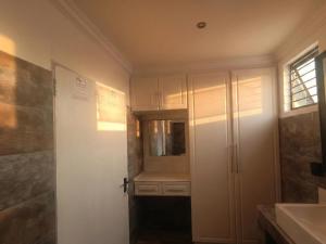 a bathroom with a sink and a white door at Picasso - Zur See in Ballito +5 photos