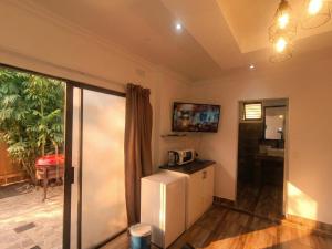 a kitchen with a refrigerator and a microwave at Picasso - Zur See in Ballito