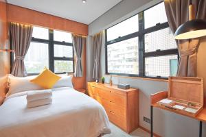 a bedroom with a large bed and windows at Oootopia Tai Kok Tsui in Hong Kong
