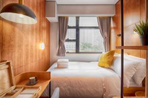 a small bedroom with a bed and a window at Oootopia Tai Kok Tsui in Hong Kong