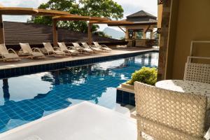 a swimming pool with lounge chairs next to a house at Coron Westown Resort Premier in Sampong